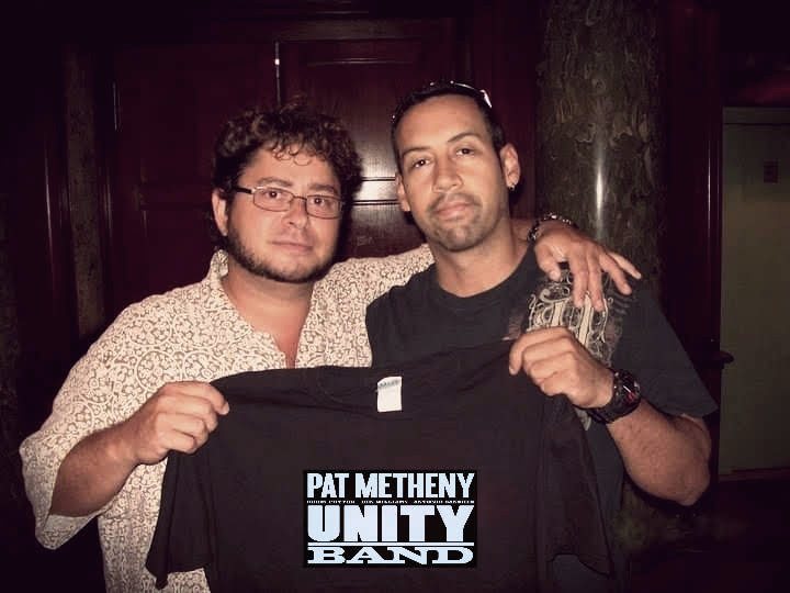 Yan Kayary y Antonio Sánchez sostienen una camiseta de Pat Metheny Unity Band